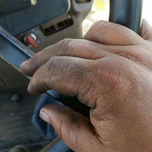 A farmers dirty hands as he works on farm equipment